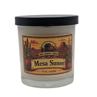 An 8 oz glass jar candle with a black lid and a vintage-style label reading 'Mesa Sunset' and 'Red Caboose Candle Co.', shown on a plain white background.